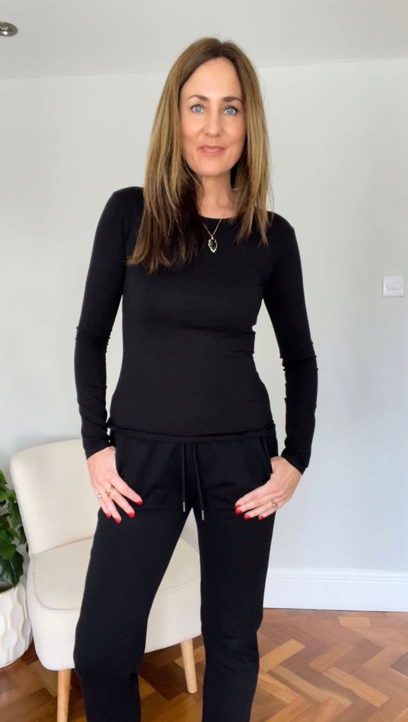 Tall women's black top styled with slim joggers for minimalistic look